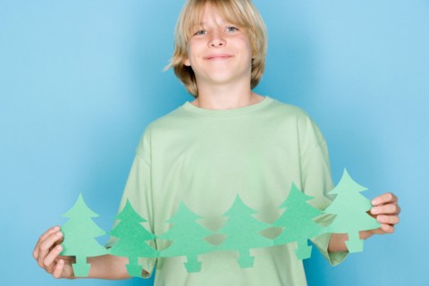 Studio shot portrait of teenage boy holding paper chain, waist up. Photo : Rob Lewine