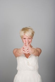 Studio shot portrait of mid adult woman aiming in viewer's side, waist up. Photo : Rob Lewine