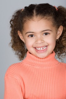 Studio shot portrait of smiling girl, head and shoulders. Photo : Rob Lewine