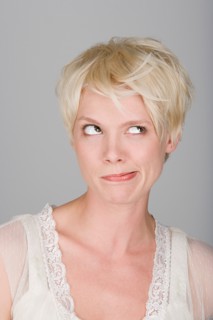 Studio shot portrait of mid adult woman blowing hair over face, close-up. Photo : Rob Lewine