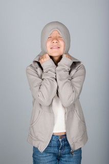 Studio shot portrait of teenage girl in hooded shirt, waist up. Photo : Rob Lewine