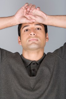 Studio shot portrait of mid adult man with arms raised, head and shoulders. Photo : Rob Lewine