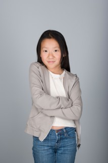 Studio shot portrait of teenage girl with arms crossed, waist up. Photo : Rob Lewine