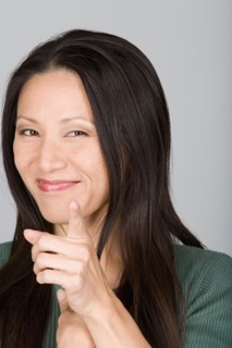 Studio shot portrait of mid adult woman pointing at viewer, head and shoulders. Photo : Rob Lewine