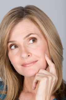 Studio shot portrait of mature woman with hand on chin, close-up. Photo : Rob Lewine