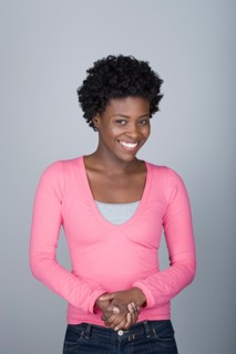 Studio shot portrait of mid adult woman with hands clasped, waist up. Photo : Rob Lewine