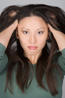 Studio portrait of stressed Chinese woman. Photo : Rob Lewine