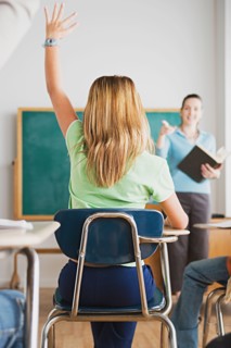 Girl rising hand in classroom. Photo : Rob Lewine