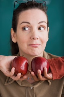 Teacher being offered tow apples by pupils. Photo : Rob Lewine