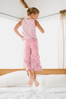 Girl jumping on bed. Photo : Rob Lewine