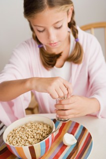 Girl (12-13) eating breakfast. Photo : Rob Lewine