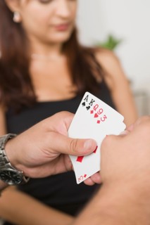 Man's hands holding cards. Photo : Rob Lewine