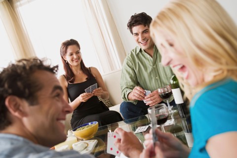 Couples on sofa at home party playing cards. Photo : Rob Lewine