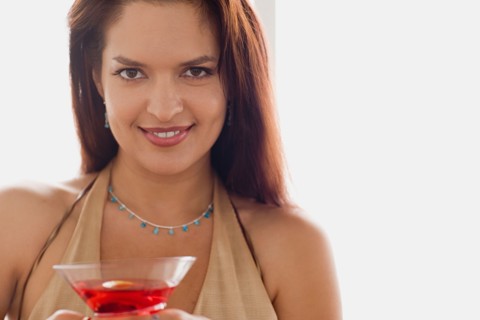 Portrait of smiling mid adult woman holding cocktail. Photo : Rob Lewine