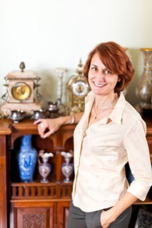 Smiling woman with her collection of antiques. Photo :  Elena Elisseeva