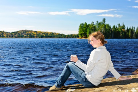 Canada, Ontario, Algonquin Park, Teenage girl sitting on rock and looking at lake. Photo :  Elena