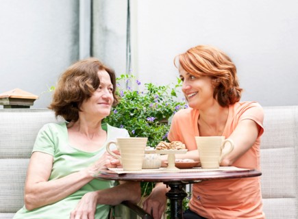 Mother and daughter having coffee in backyard. Photo : Elena Elisseeva