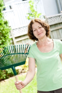 Senior woman with rake in garden. Photo : Elena Elisseeva