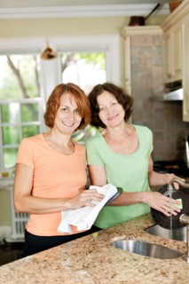 Mother and daughter doing dishes in kitchen. Photo : Elena Elisseeva