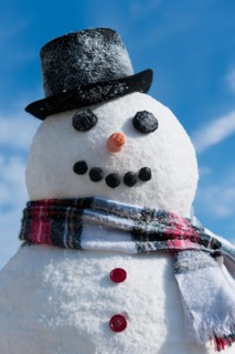 Snowman under blue sky.