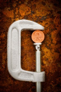 Studio shot of coin in vise grip.