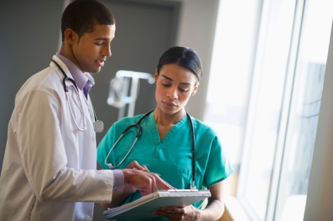 Doctor and nurse talking in hallway.