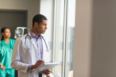 Doctor looking through window.