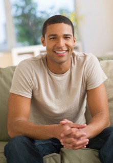 Portrait of man sitting on sofa.