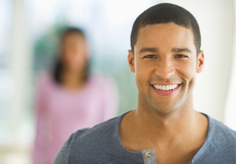Portrait of man smiling, woman in background.