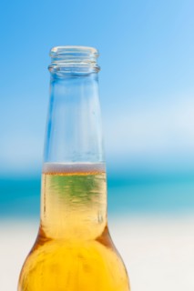 Beer bottle on beach.