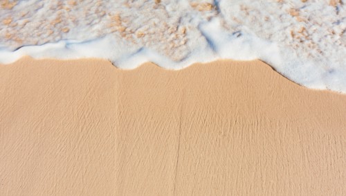 Mexico, Yucatan. Sea waves on beach sand.