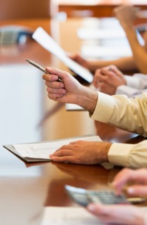 Hands of business people at business meeting.
