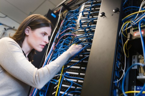 Female IT support technician repairing server.