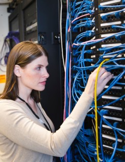 Female IT support technician repairing server.