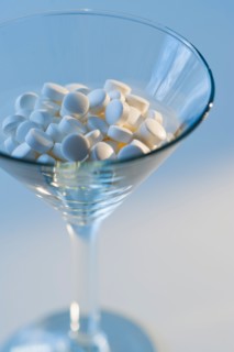 Martini glass filled with pills, studio shot.