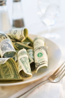 Paper currency on dinner plate, studio shot.
