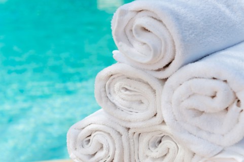 Rolled up towels in front of water.