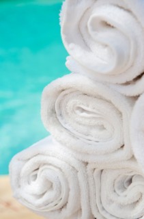 Rolled up towels in front of water.