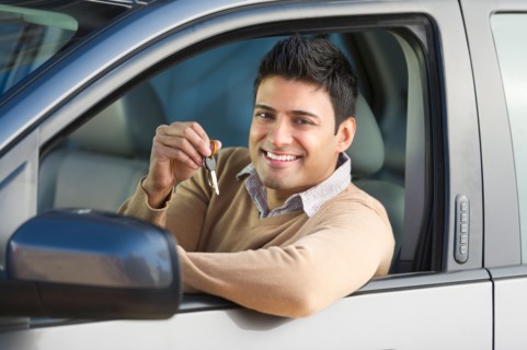 Man sitting in his new car.