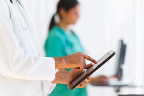Doctors working on digital tablet and computer.