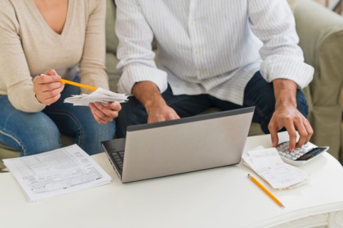 Couple using laptop and calculator.