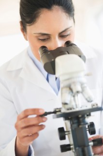 Scientist looking through microscope.