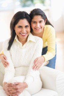 Portrait of mother and daughter (12-13) at home.