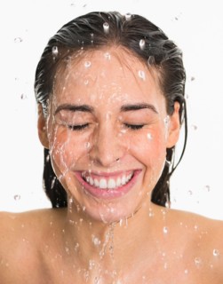 Studio shot of woman with splash of water on face.