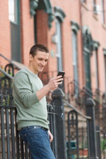 Man using smart phone on street.