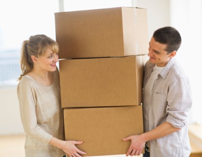 Couple carrying cardboard boxes during relocation.