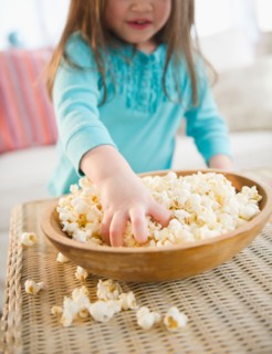 Small girl  (4-5 years) eating popcorn. Photo : Jamie Grill