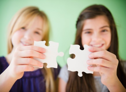 Close up of hands of girls holding jigsaw puzzles. Photo : Jamie Grill