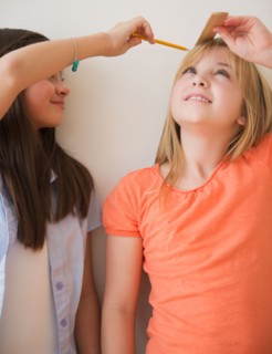 Two girls measuring height. Photo : Jamie Grill