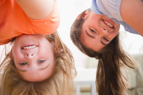 Close up of two girls upside down. Photo : Jamie Grill